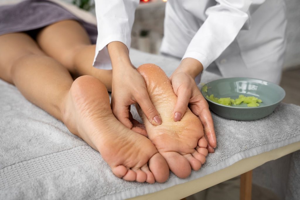 масажист прави пилинг на ходила
