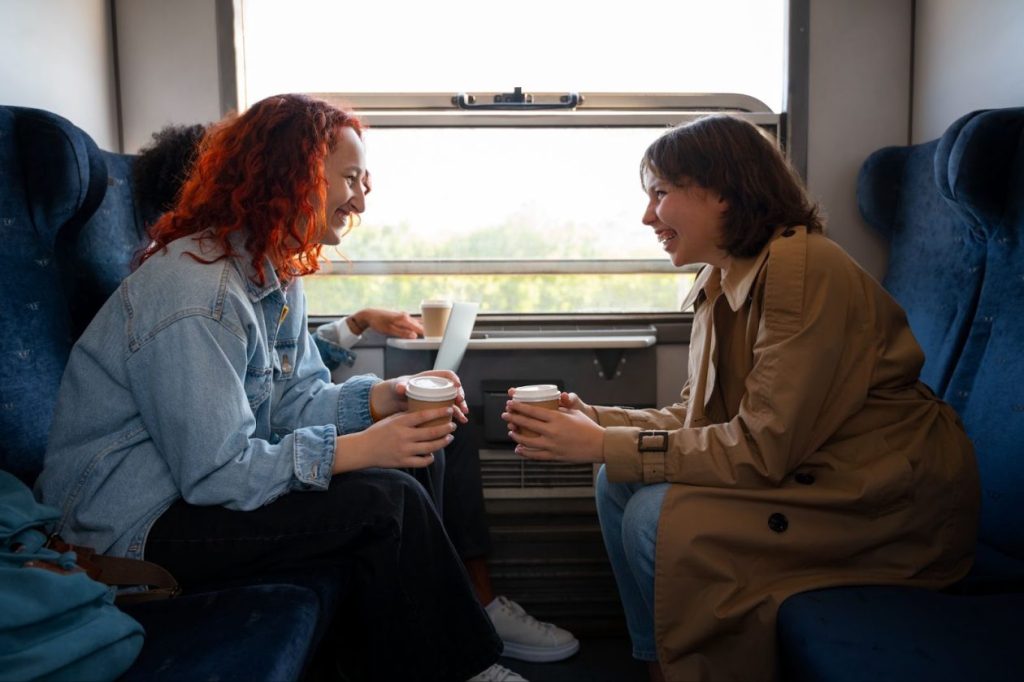 Две приятелки си говорят в купето на влак.