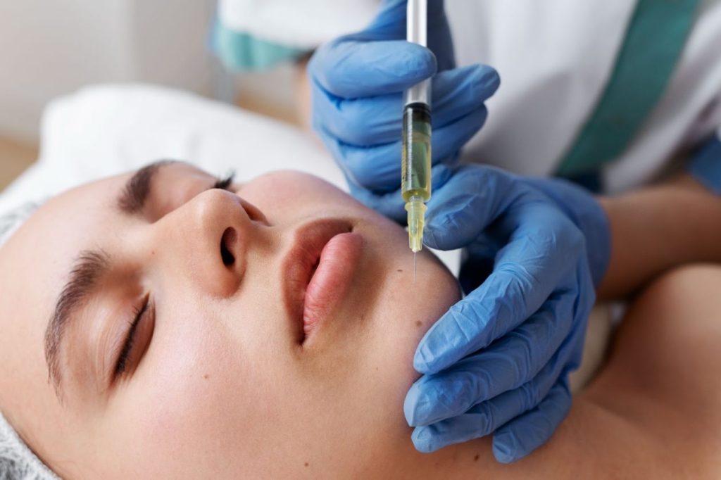 Специалист извършва плазмотерапия за подмладяване на лицето на жена.